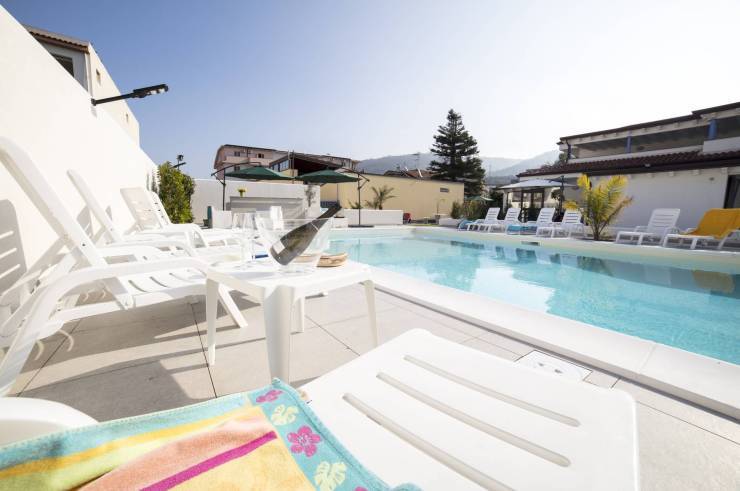 Chaises longues au bord de la piscine pendant un apéritif