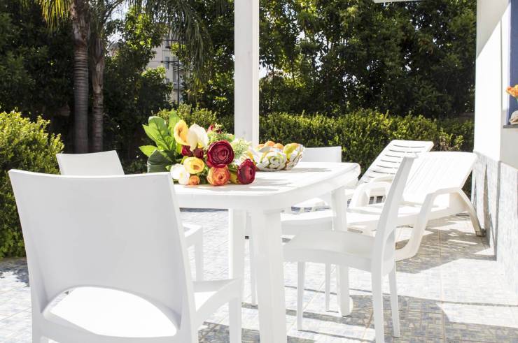 Außenbereich auf der Gartenseite mit Tisch, Stühlen und Sonnenliegen ausgestattet